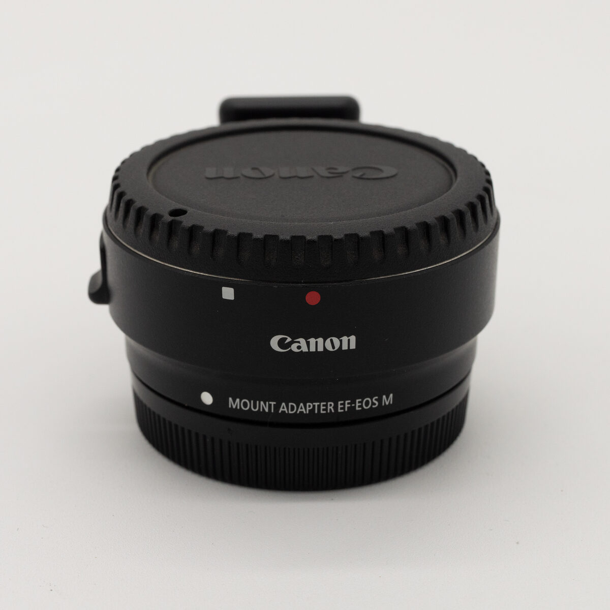Adaptador Canon EF-EOS M — vista frontal en ángulo con tapa Canon (pieza real en venta)